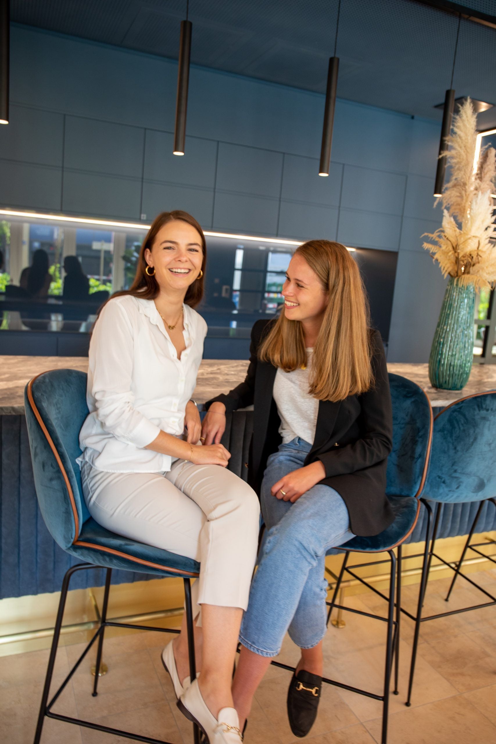 Two consultants sitting on chairs and smile